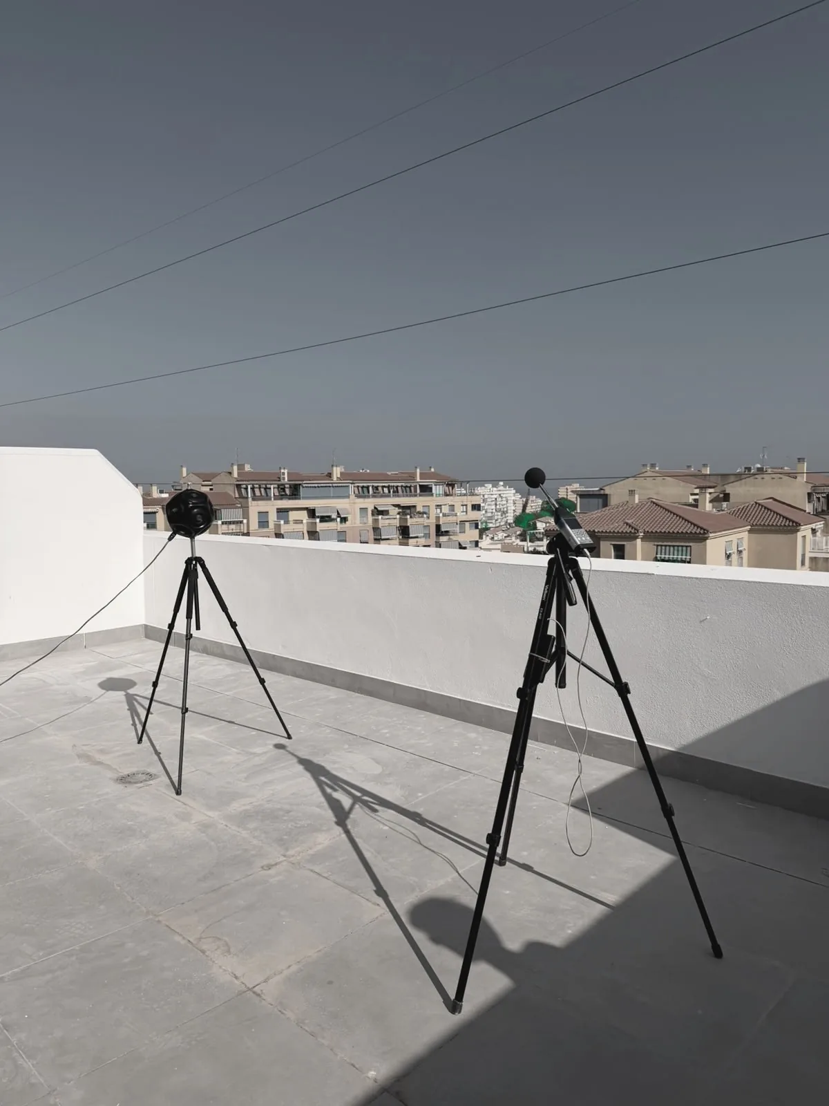Dos equipos de medición acústica instalados en una terraza para una comprobación exterior
